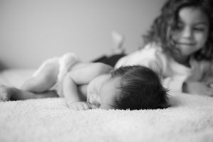 Close-up black and white portrait of sleeping newborn baby on soft blanket.