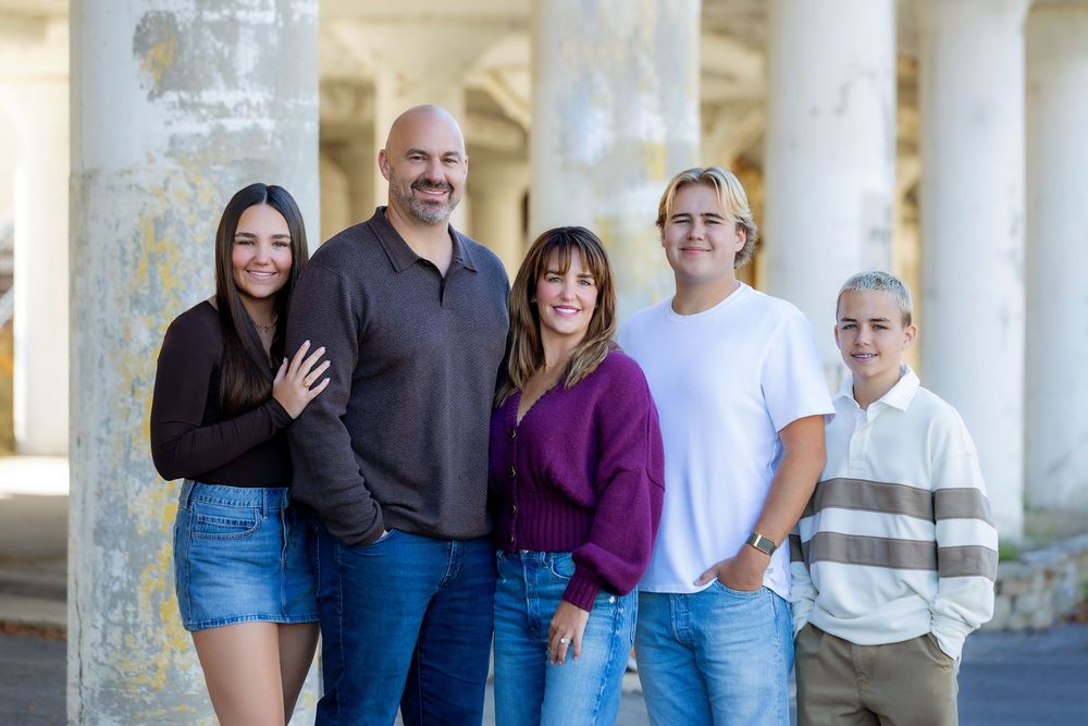 Group photo taken under white pillars and archways in casual clothing.