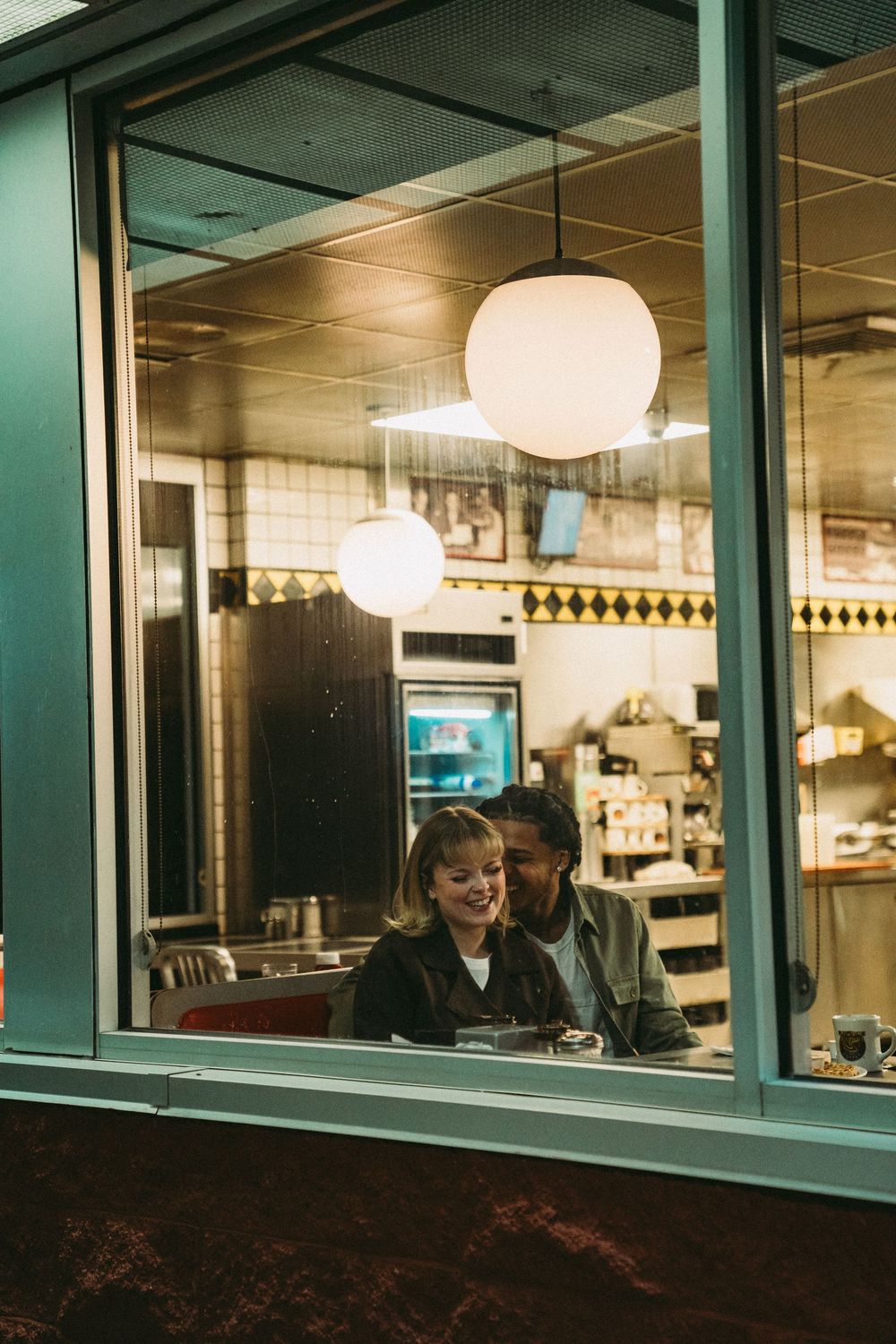 People working at night in an office building with illuminated windows and modern lighting fixtures.