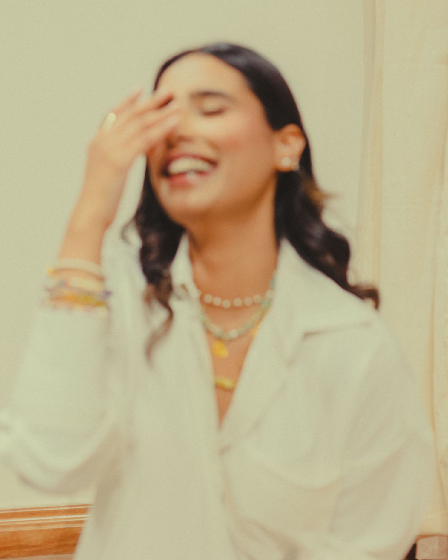 Candid portrait series in white blazer with soft lighting and joyful expressions.