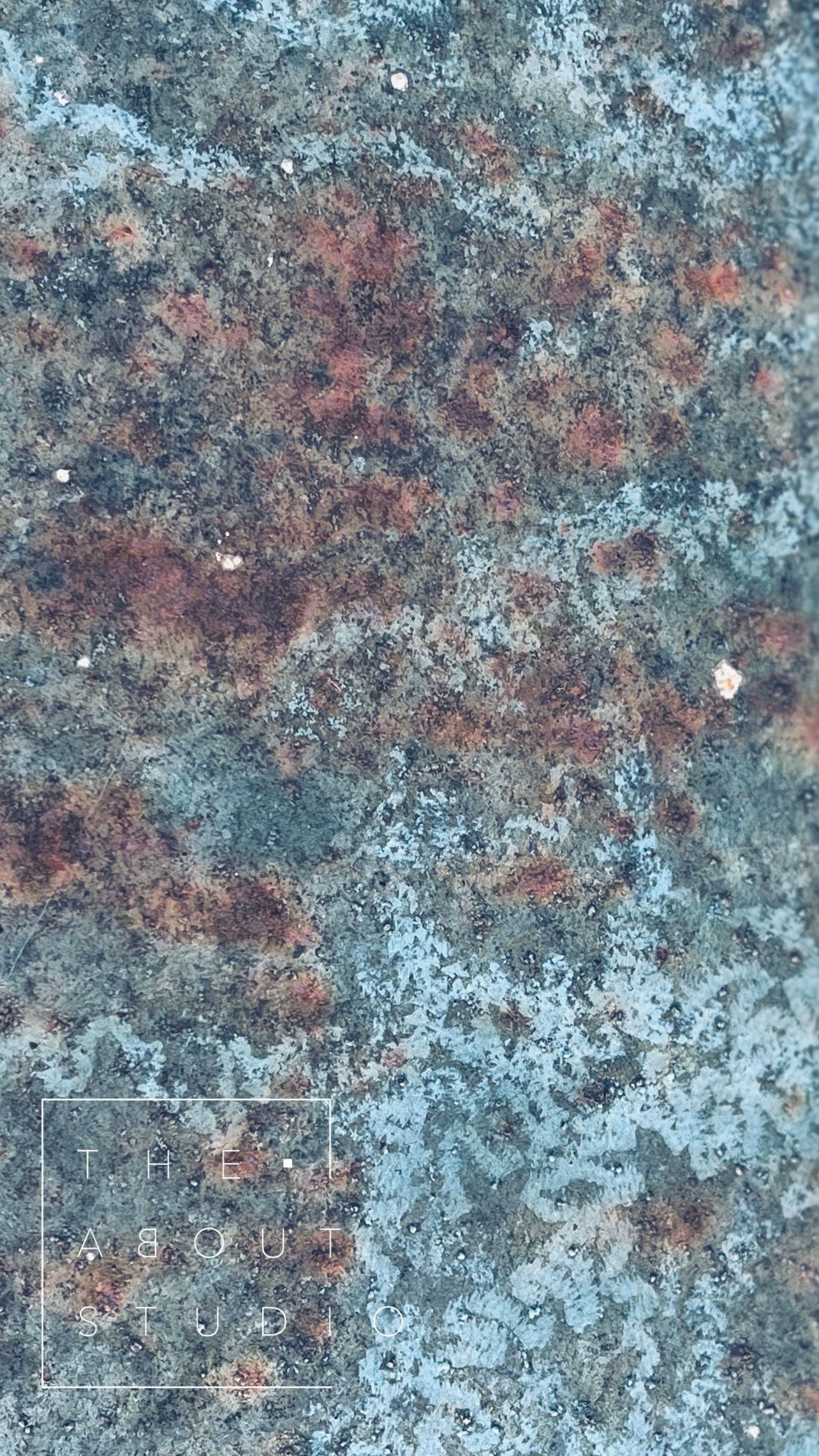 Abstract textured surface in blue and rust tones with subtle studio branding overlay.