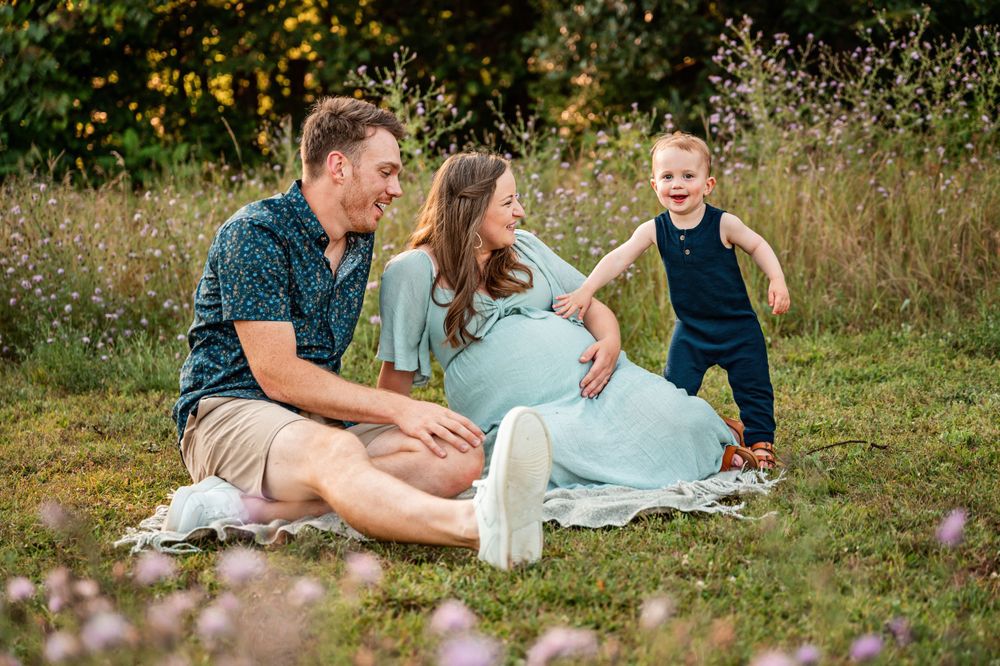 A joyful outdoor family photo session in a wildflower meadow during golden hour.