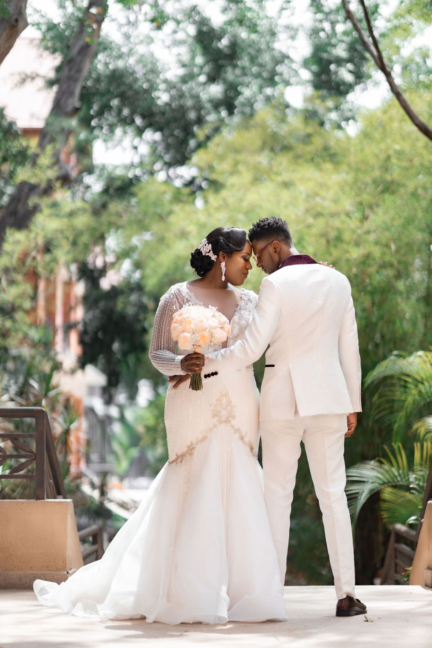 Wedding celebration in a pink-lit reception room with elegant table settings.