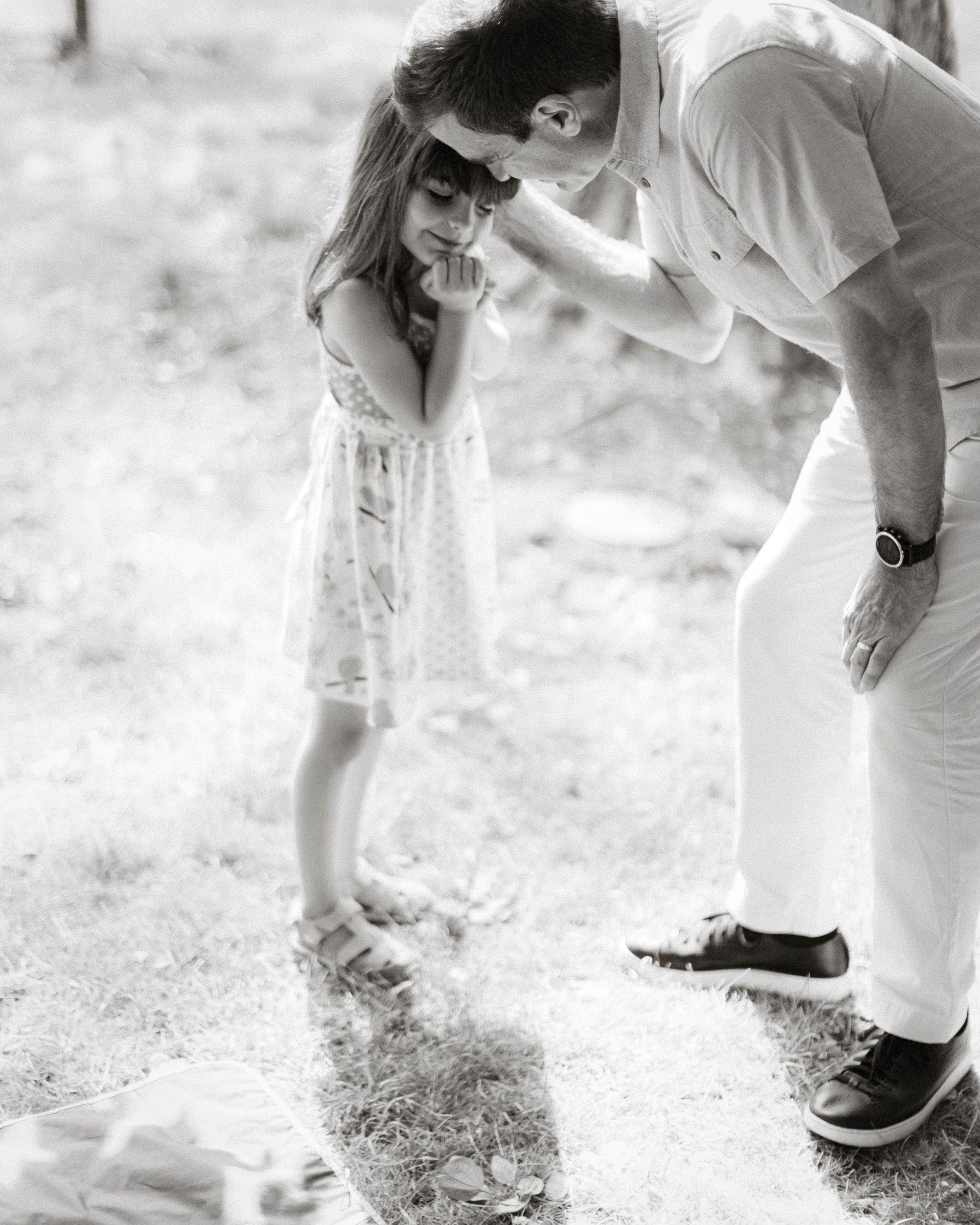 A tender black and white moment between parent and child in an outdoor setting.