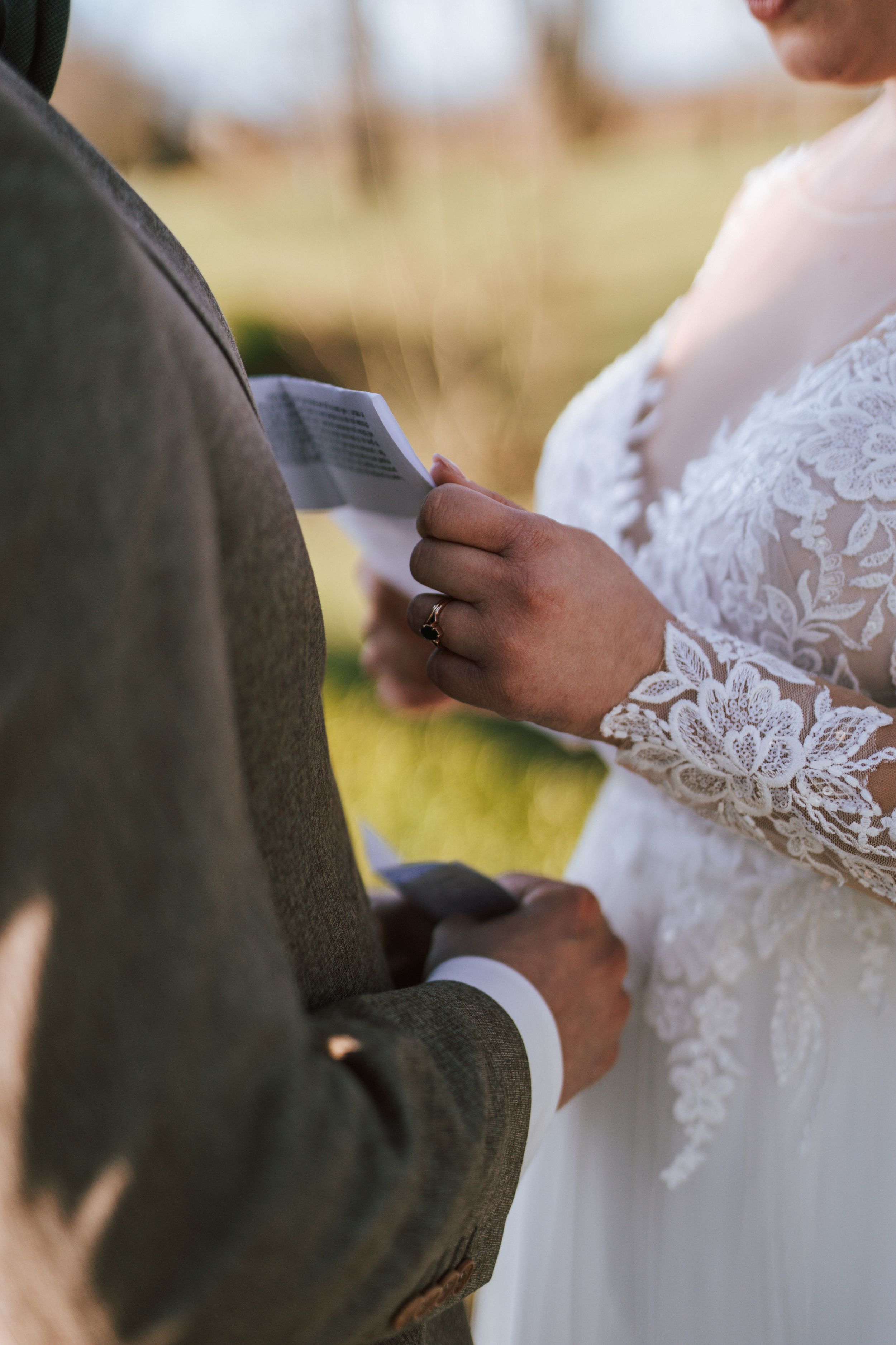 Close-up of wedding vows being read from paper during an outdoor ceremony.
