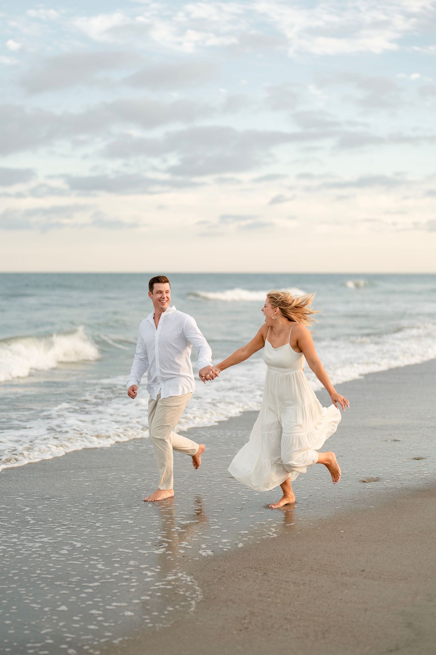 Couple running on the beach in Pawleys Island, engagement session