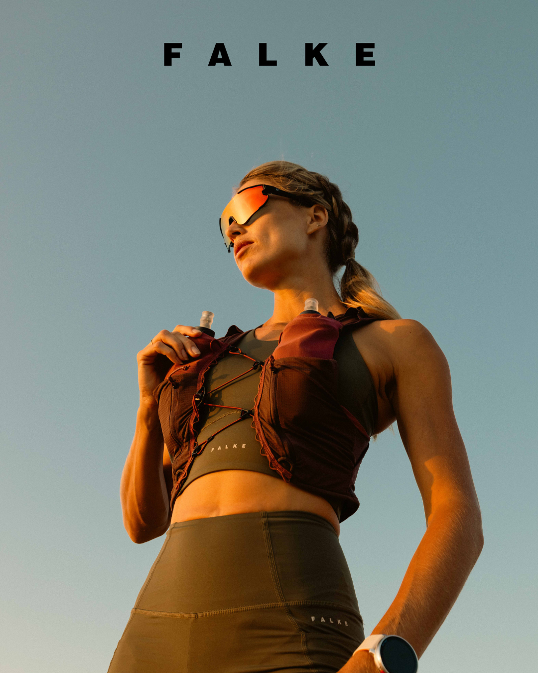 Falke activewear advertisement featuring athletic apparel in warm sunset lighting.