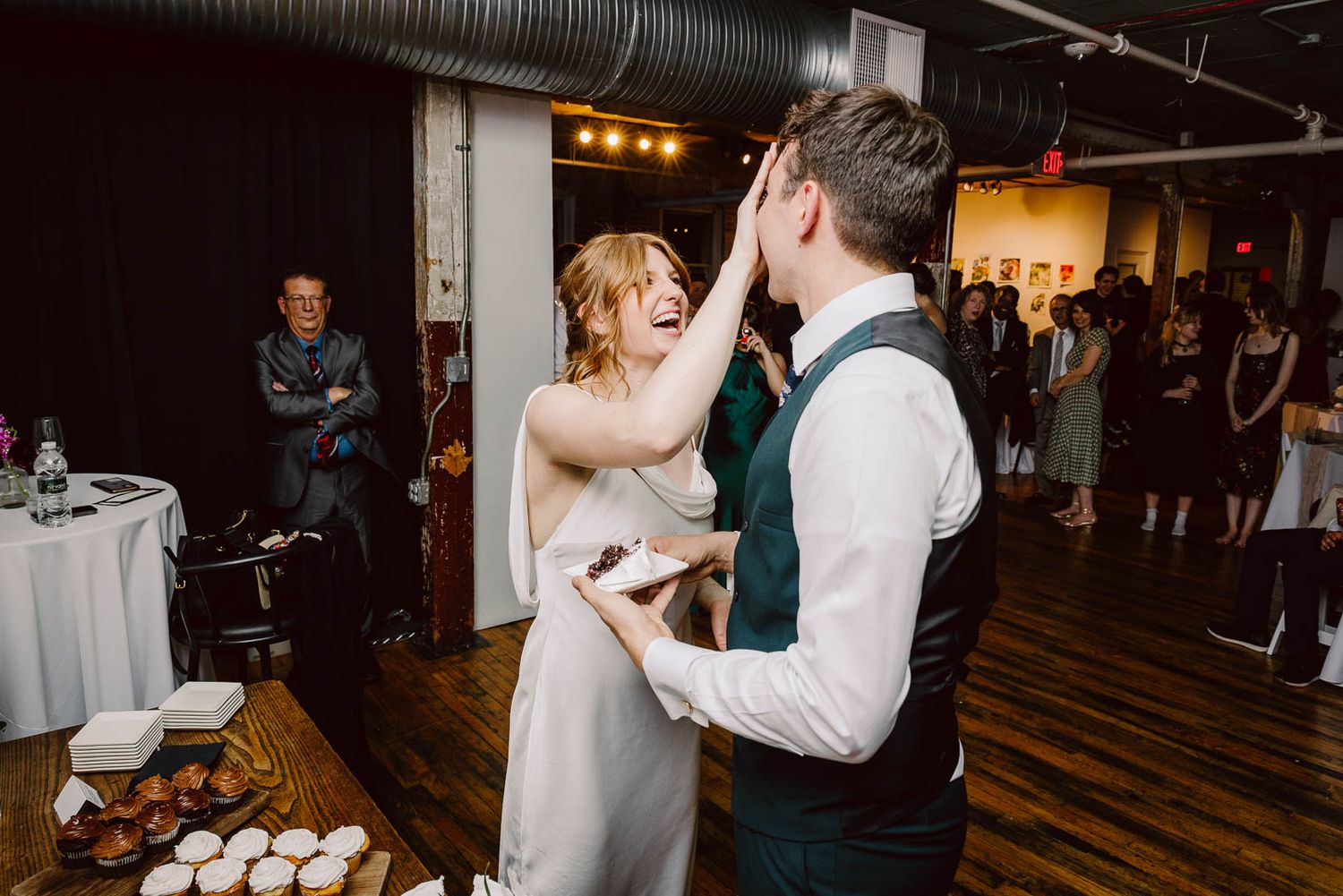 Playful wedding cake smash during the couples cake cutting captured by Cleveland wedding photographer.