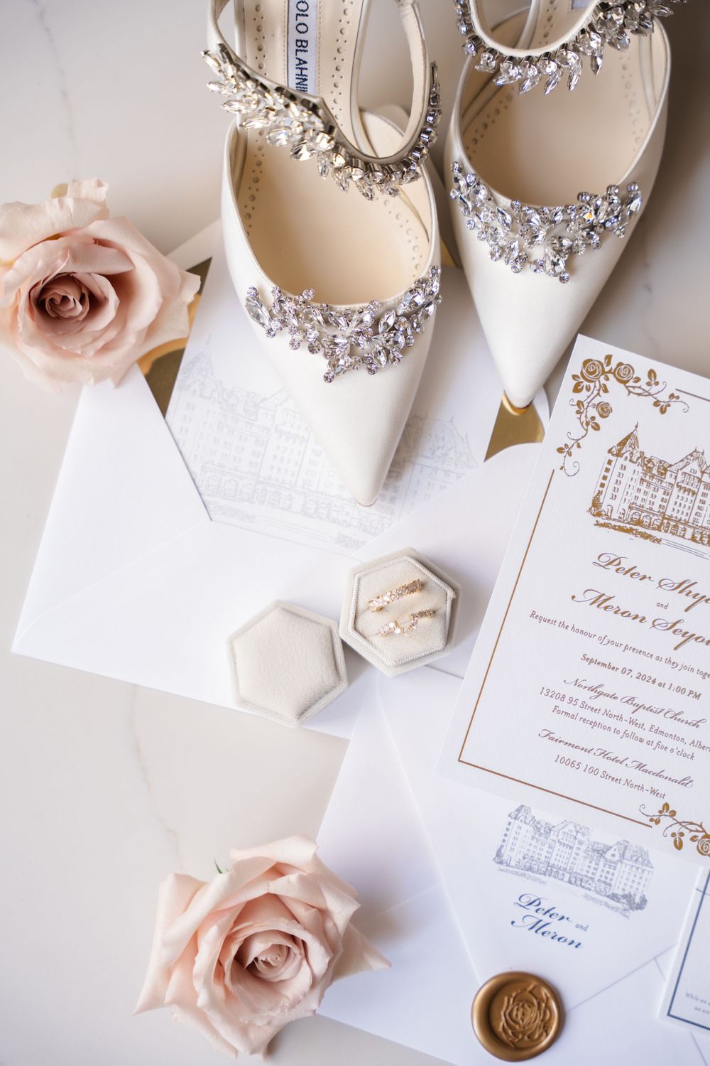 Elegant wedding details featuring invitations, roses, and crystal-embellished bridal shoes.
