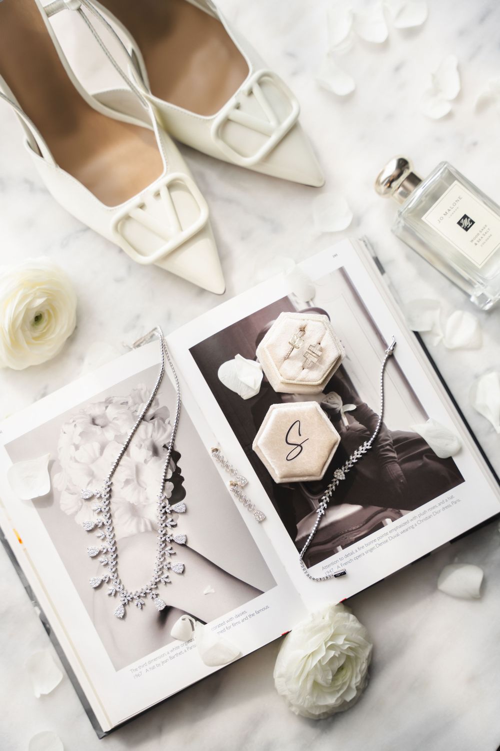 Wedding accessories flatlay with white shoes, perfume, and jewelry photos on white background.