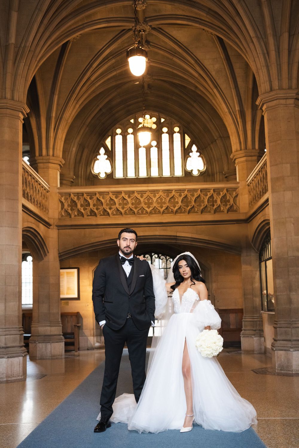 Elegant wedding portrait under grand cathedral arches with gothic architectural details.