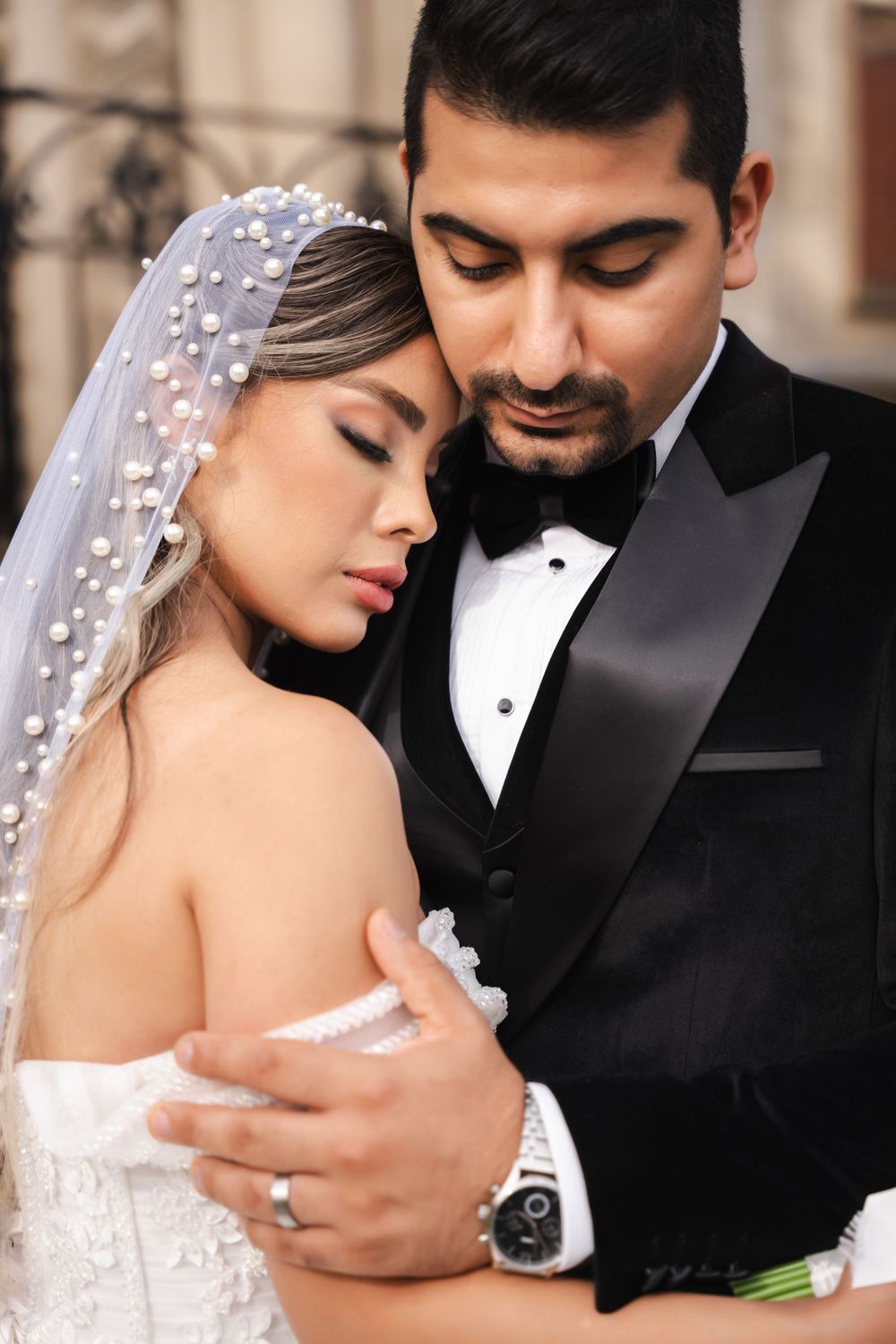 Intimate wedding portrait of couple embracing in formal attire.