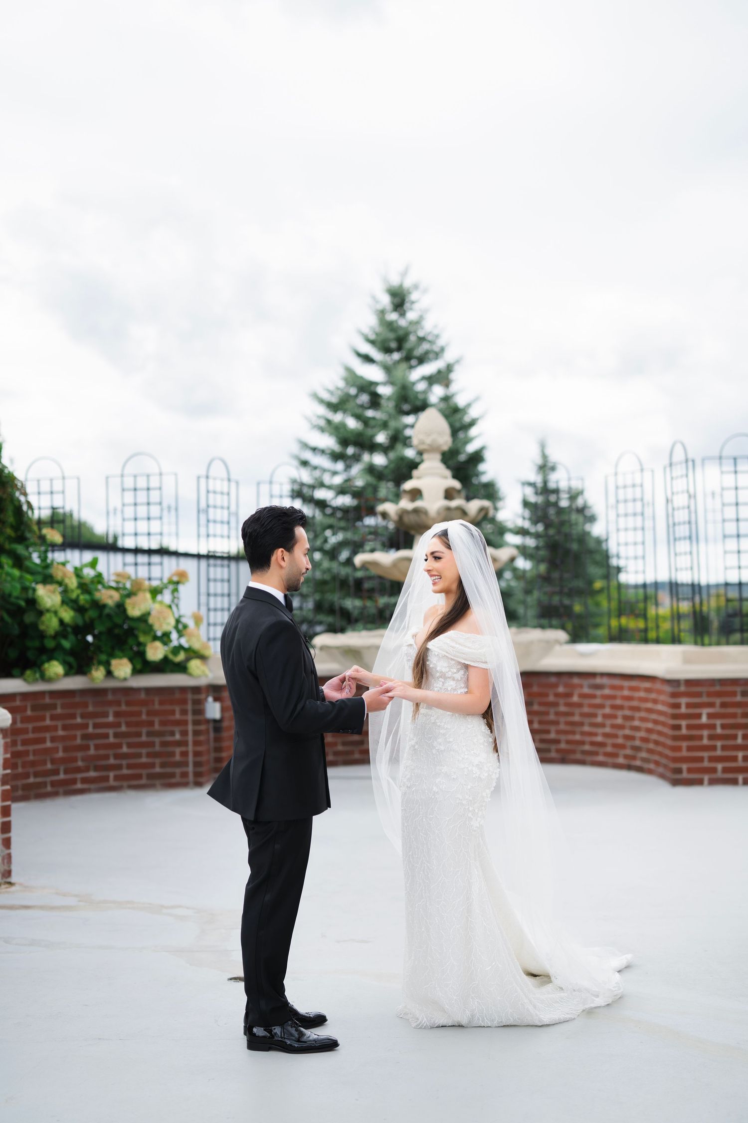 Wedding couple shares intimate first look moment on outdoor terrace.