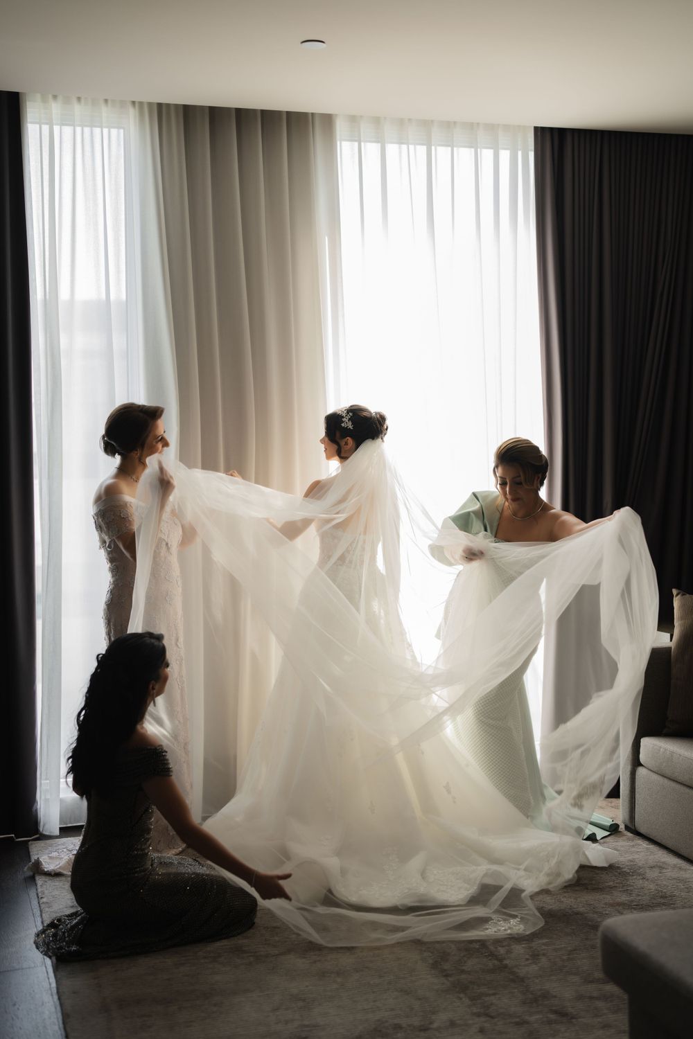 Series of artistic getting ready photos showing billowing white wedding dress fabric in a hotel room.
