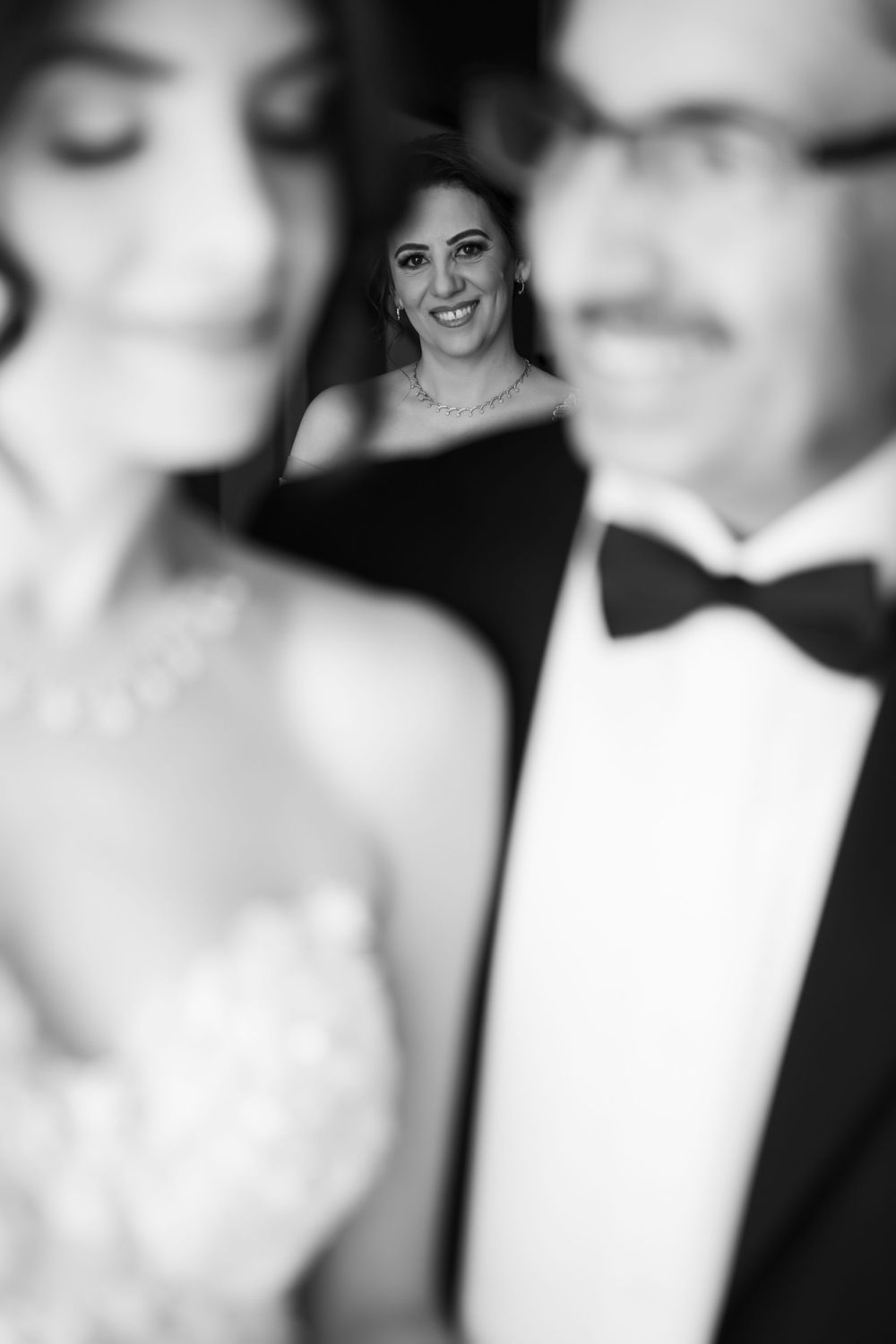 Black and white portraits of a newlywed couple in elegant wedding attire.