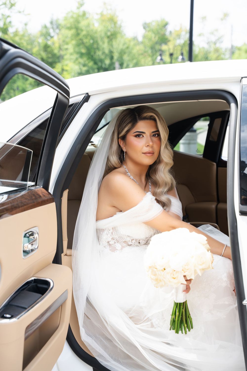 Elegant bride sits in a luxury car holding a white bouquet, captured in a series of moments before her wedding.
