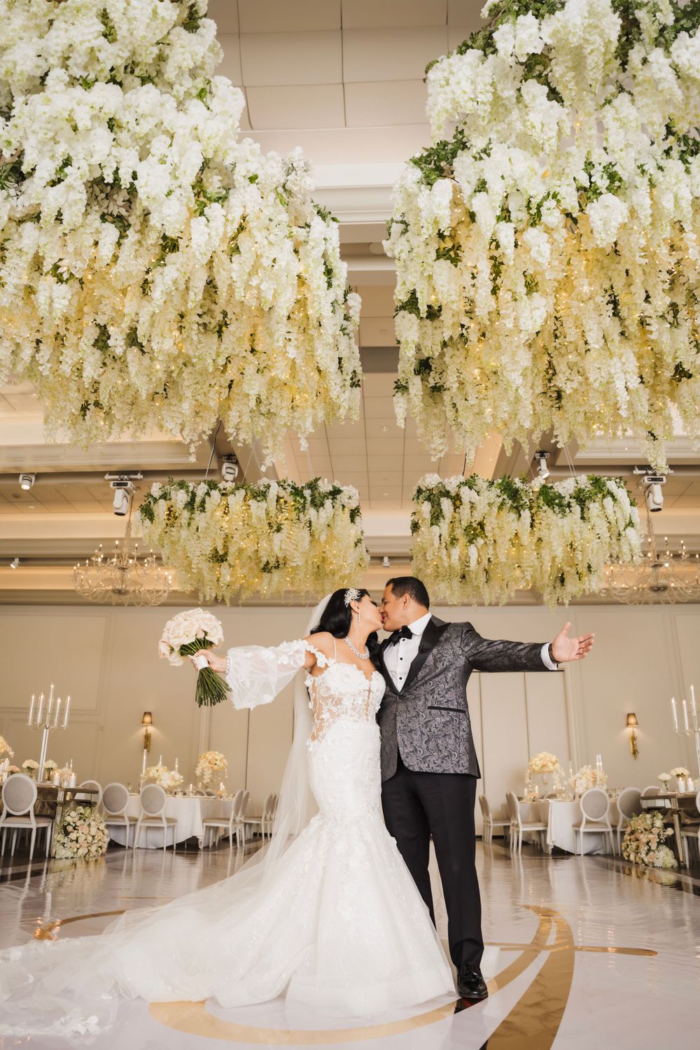 Stunning white floral ceiling installation over an elegant wedding reception space.