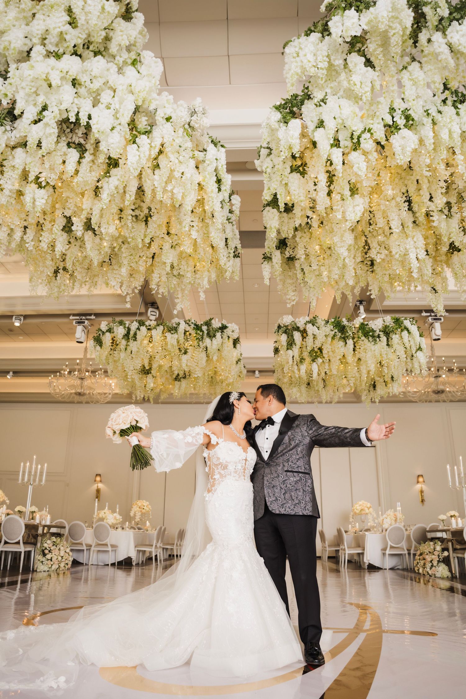 Stunning white floral ceiling installation over an elegant wedding reception space.