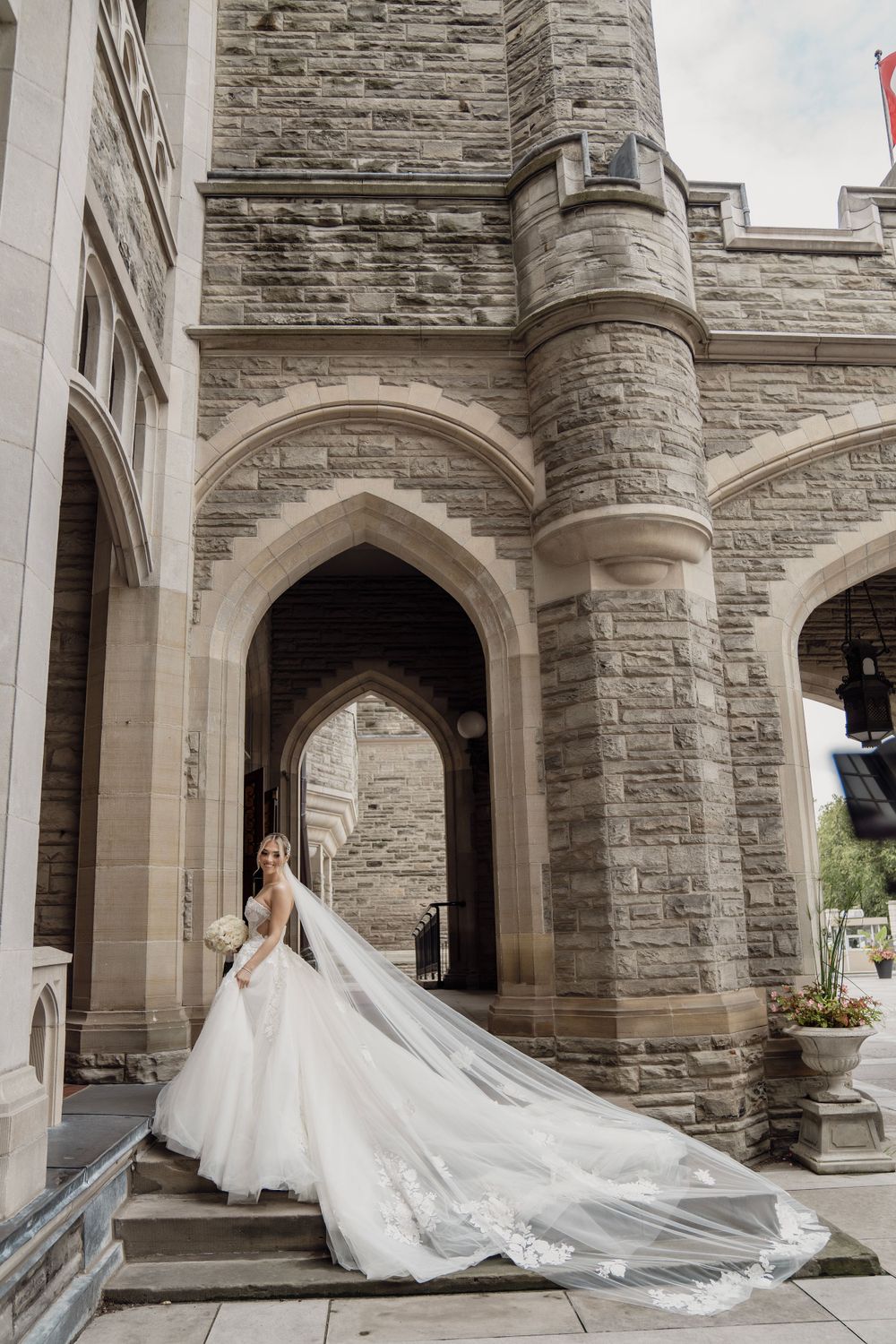 Dramatic cathedral wedding photos showcasing flowing train against stone gothic architecture.