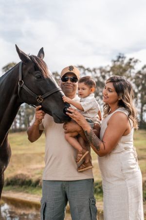 a family and their toddler boy petting their horse during a photoshoot in Dural