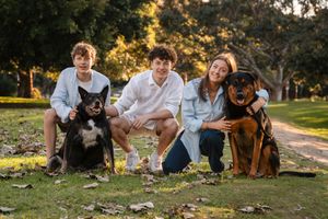 siblings and their dogs smiling during a family photoshoot in Mosman