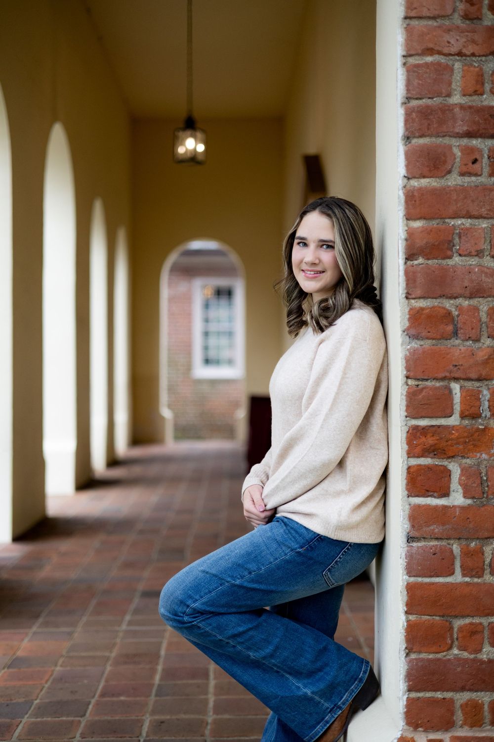 A series of portrait photos taken in a brick archway corridor with terra cotta flooring.