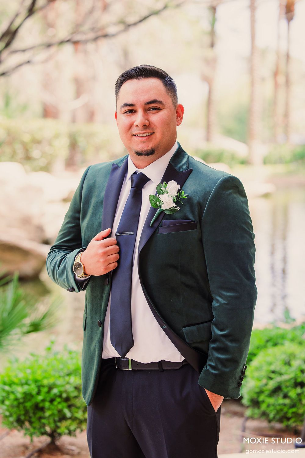 A series of formal portraits showing a groomsman in a dark green velvet suit jacket and navy tie against an outdoor backdrop.