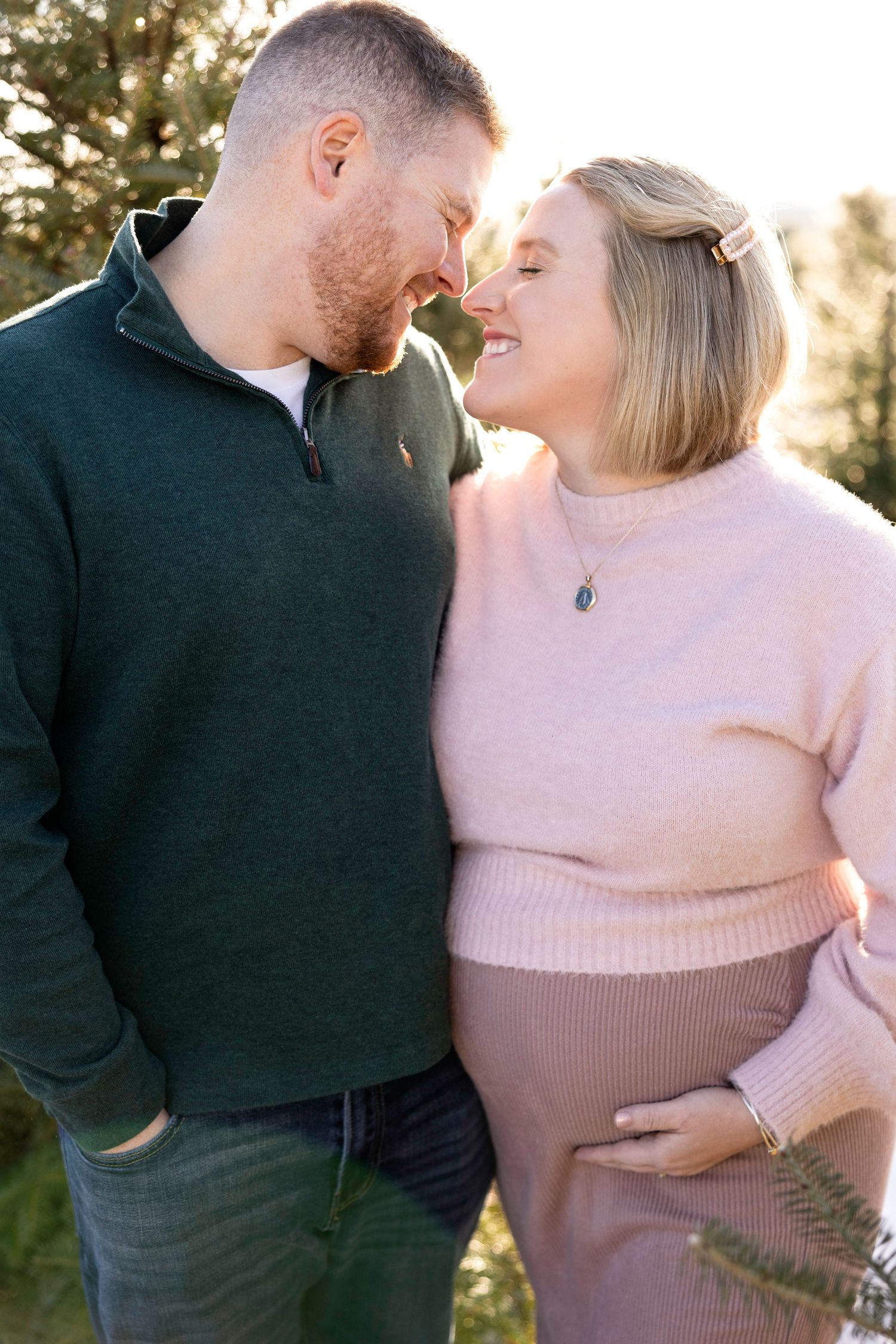 Intimate couple's maternity session in winter forest setting.