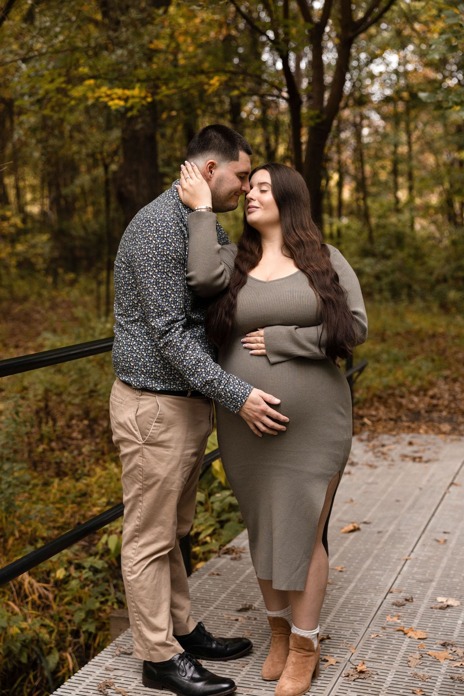 Intimate maternity photos captured on a wooden bridge during fall season.