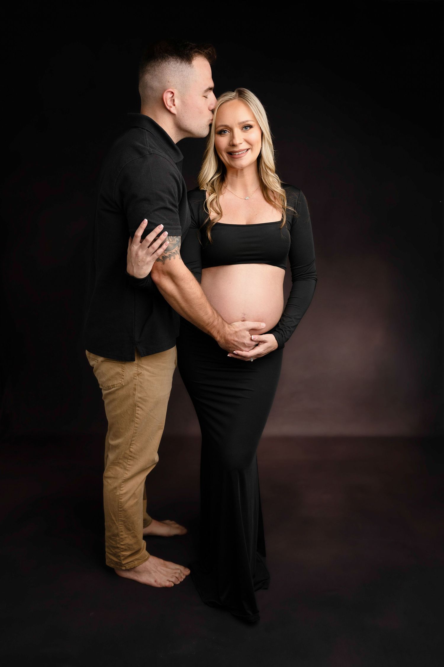 Artistic black and white maternity photos capturing tender moments between expectant couple.