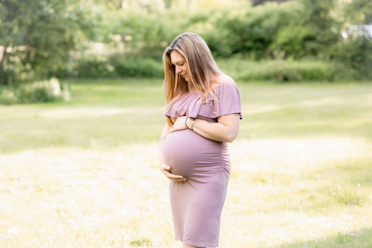 Maternity photo series in outdoor setting with soft natural lighting.