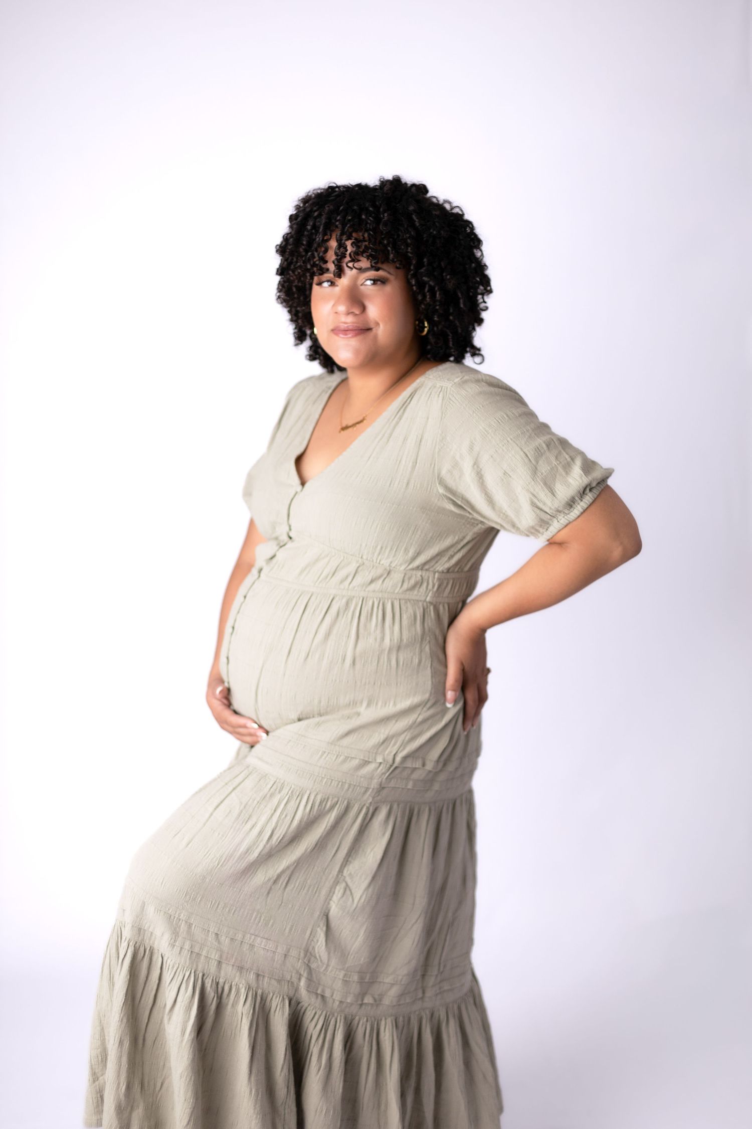Studio portraits showing flowing beige maternity dress from different angles.