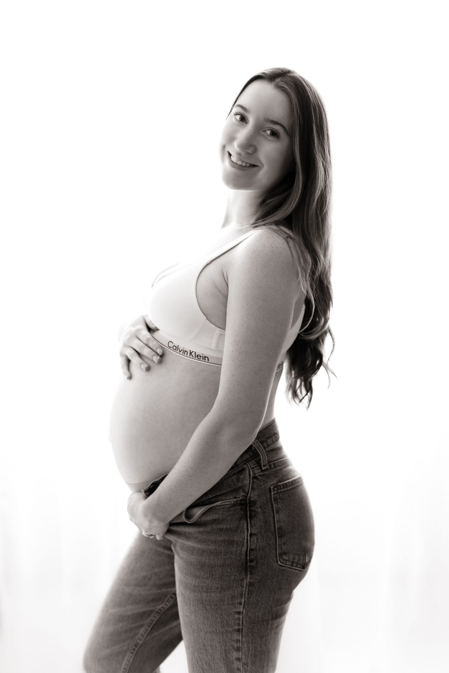 Artistic black and white maternity portraits showing silhouette against white background.