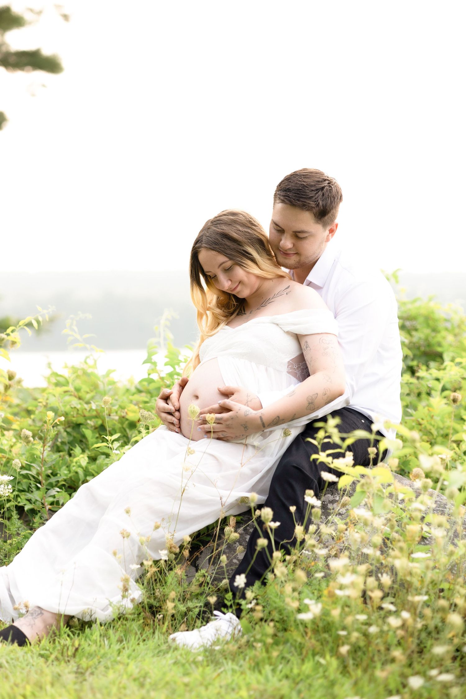 Couple sharing intimate moment while sitting in field of wildflowers.
