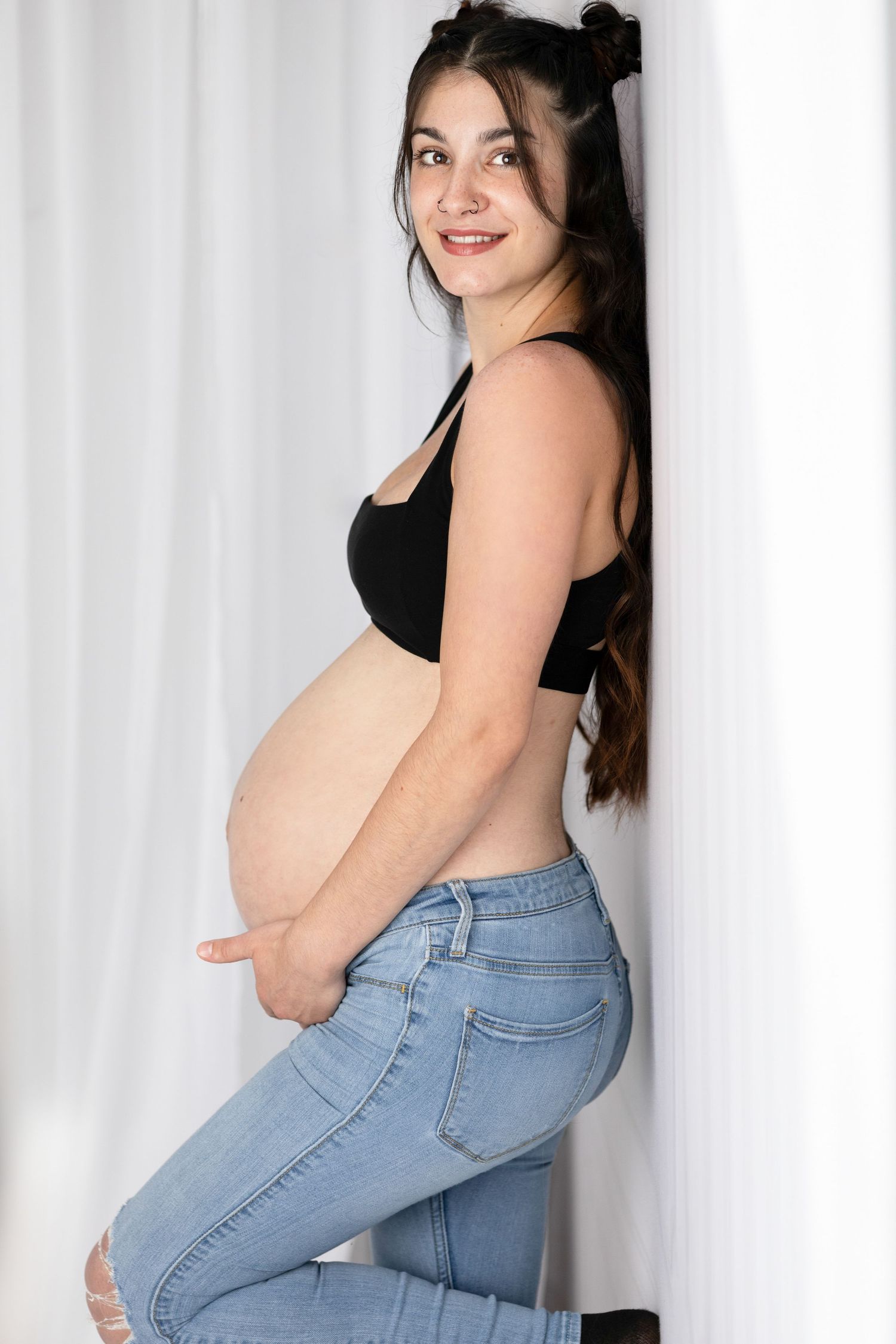 Casual maternity portrait series against white curtain background.