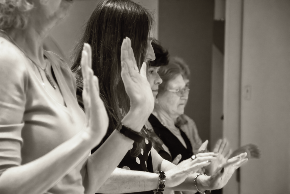 People performing synchronized hand movements during a group activity.