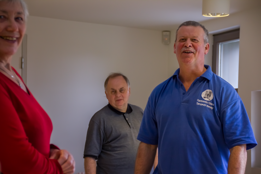 Three people sharing a lighthearted moment in a community center.