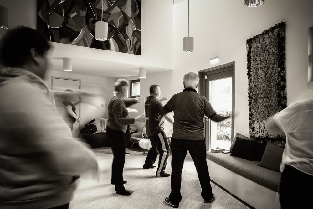Motion-blurred participants follow along during an indoor fitness class with modern decor.