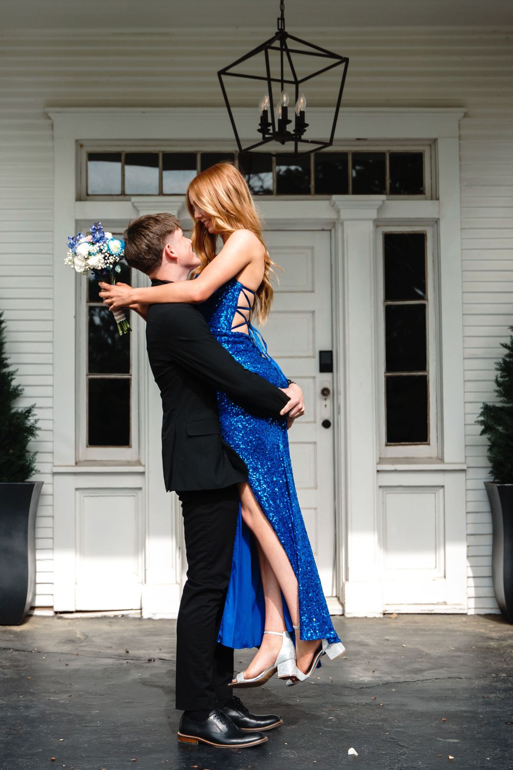 Couple sharing an intimate moment in formal wear, with her blue sequined dress sparkling.