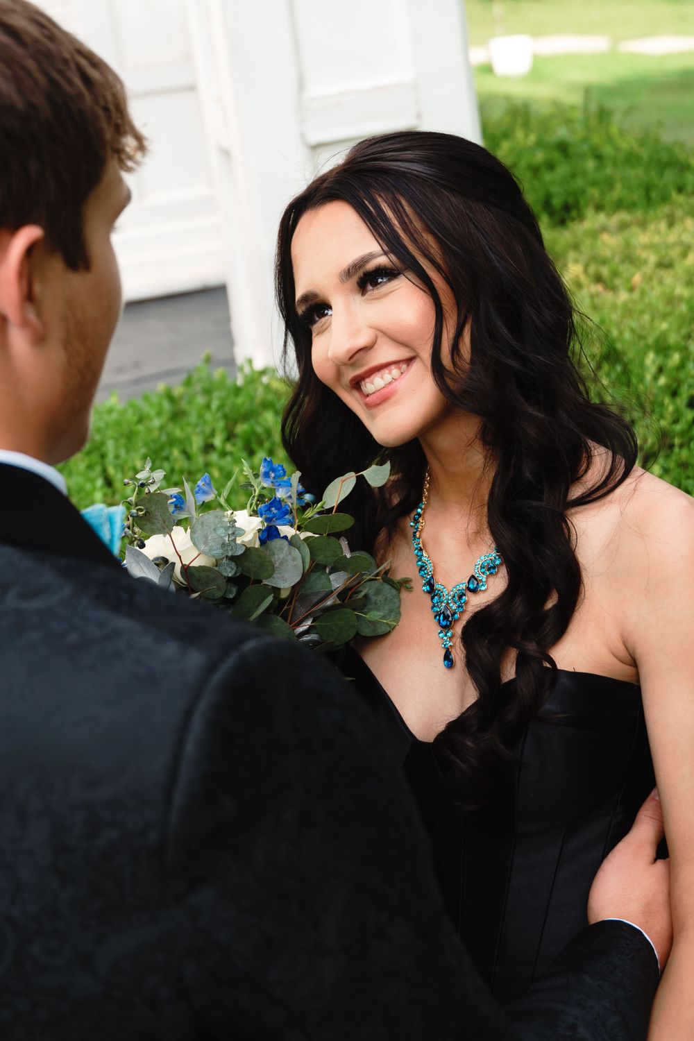 Close-up portrait in formal wear with turquoise jewelry accenting a black dress.