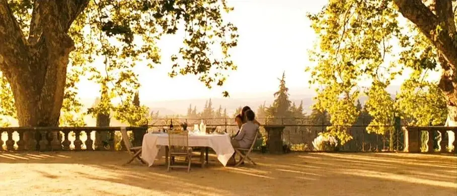 Romantic outdoor dining scene under golden sunlit trees.