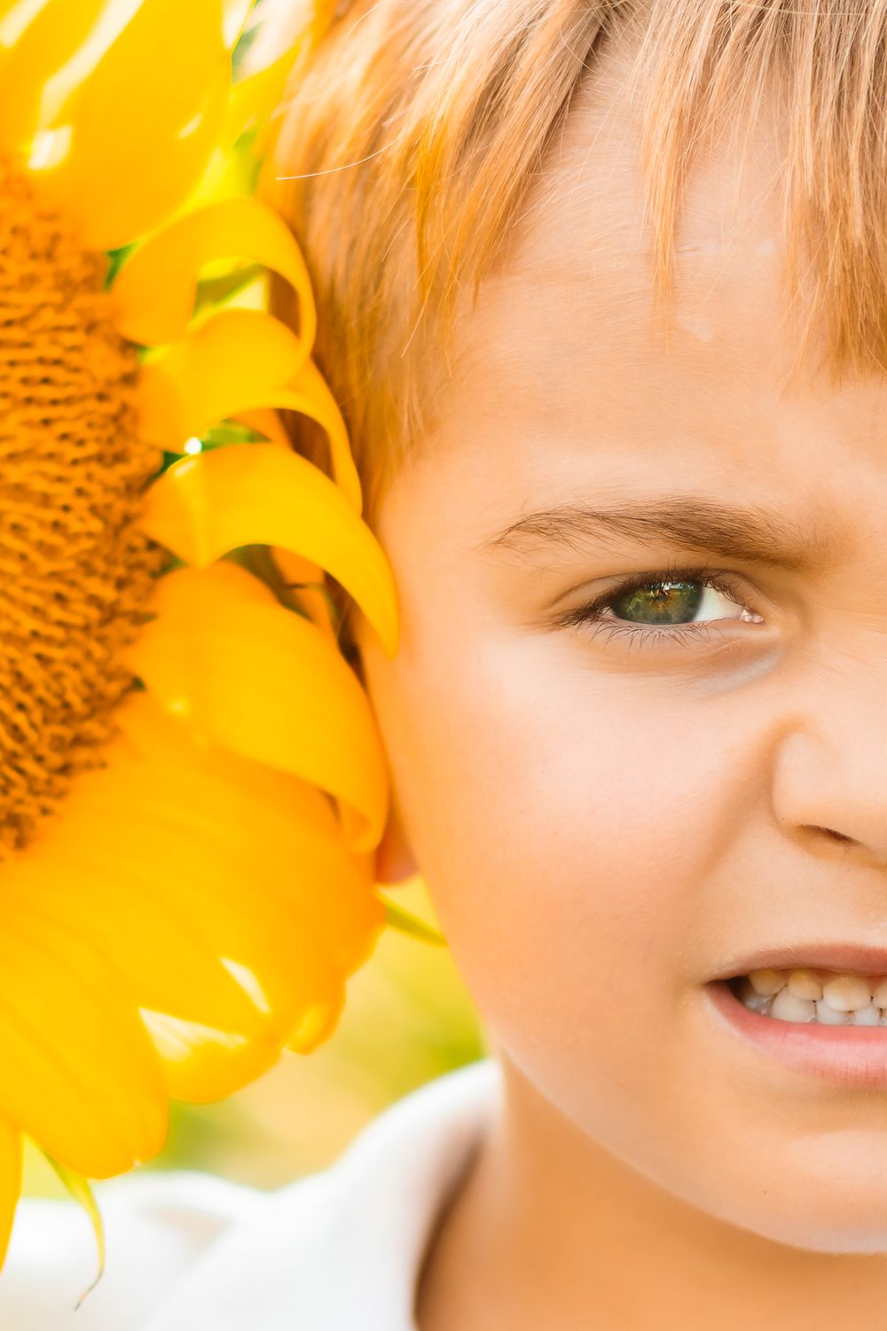 A bright yellow sunflower closeup creates a warm backdrop, highlighting a smiling face awash in golden sunlight.