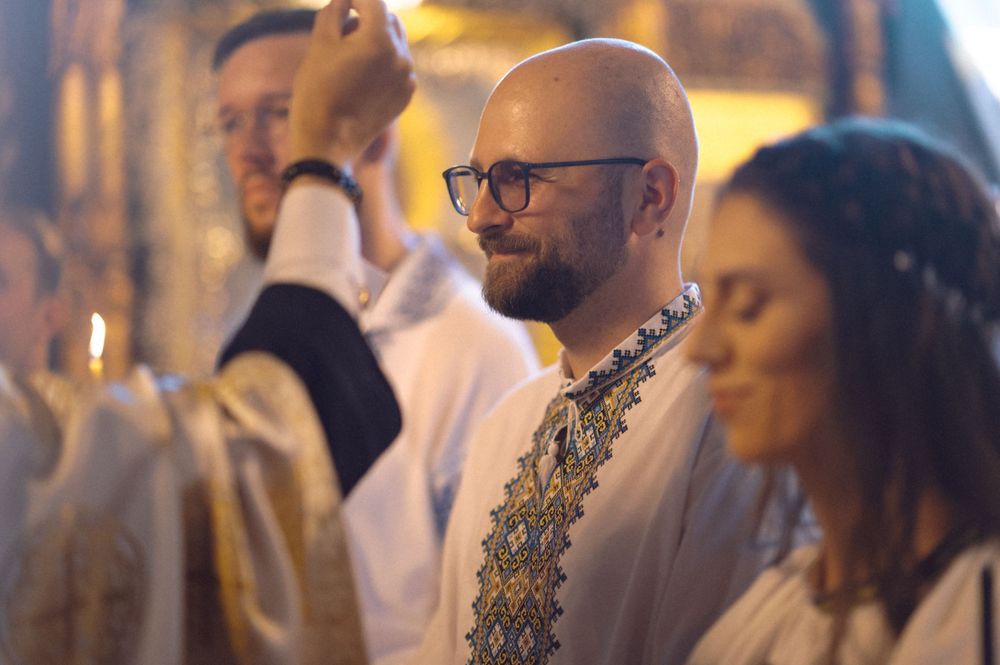 People in traditional white embroidered clothing during a ceremony.