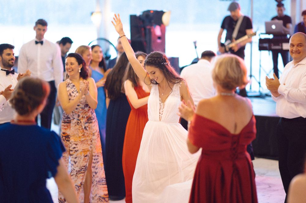Wedding guests dancing and celebrating on a bright dance floor.