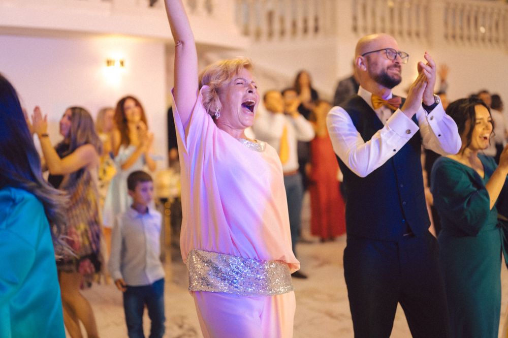 Joyful party guests dancing enthusiastically at an indoor celebration event.