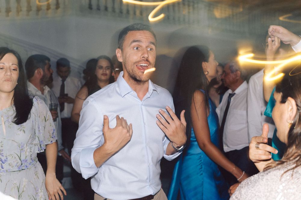 Enthusiastic guest dancing energetically at a party under warm lighting.