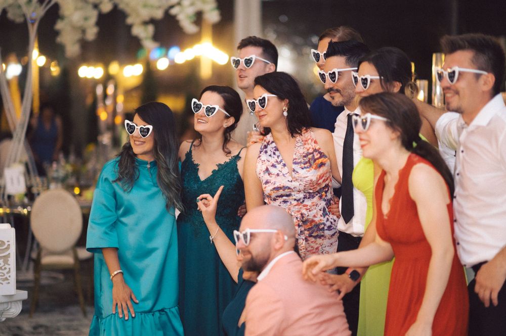 Group wearing matching retro sunglasses posing together at outdoor event.