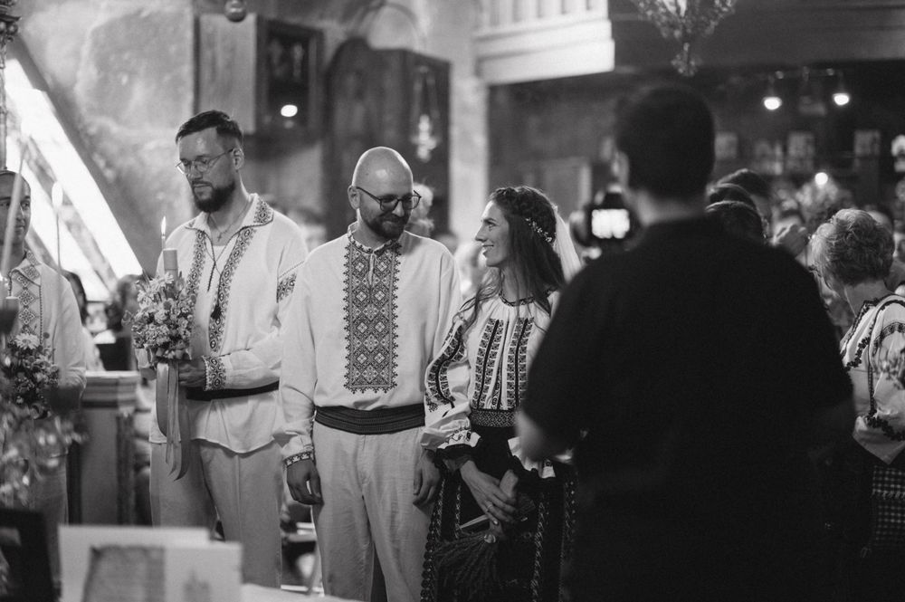 Black and white photo of Orthodox wedding ceremony with traditional embroidered attire.