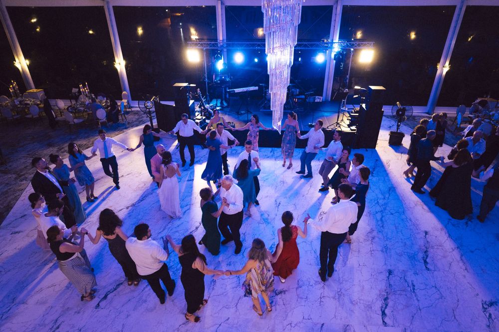 A couple on stage during what appears to be a wedding reception with stage lighting.