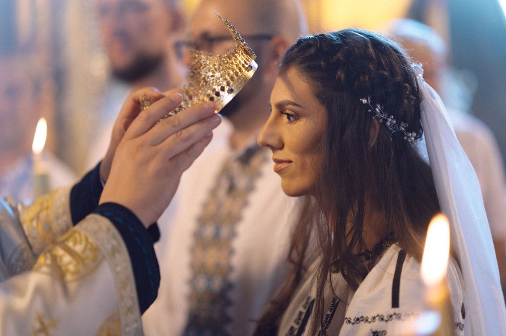 Orthodox wedding ceremony with crown blessing ritual and candlelight.